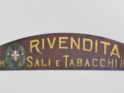 Ma l�esercizio commerciale conserva anche la prima insegna degli inizi del 900, periodo di fondazione dell�attivit�. Questa presenta addirittura lo stemma dei Savoia, a cui seguono le lettere a carattere lineare
